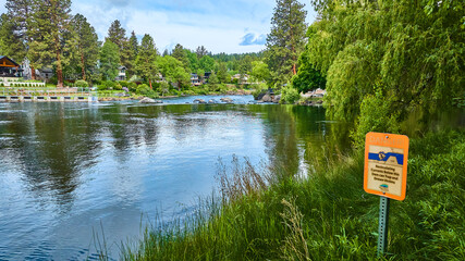 Aerial View Riverside Homes with Warning Sign and Lush Greenery
