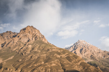 Rocky mountain a massif of red powerful rocks with snow and glaciers at sunset in the evening in the Tien Shan mountains in the Pamirs