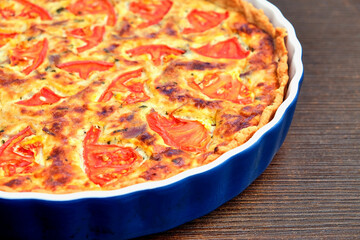 Delicious homemade quiche with fresh tomato slices and melted cheese, baked to perfection in a ceramic dish. A perfect savory pie for breakfast, brunch, or dinner.