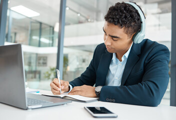 Writing, businessman and headphones with laptop in office for research, planning and project. Financial advisor, notebook and news at desk for career, online for music or podcast in workplace