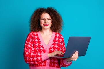 Photo of charming positive woman wear red cardigan spectacles working modern device empty space isolated blue color background