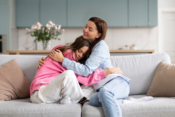 Affectionate loving mother caring and embracing her teenage daughter, expressing family connection...