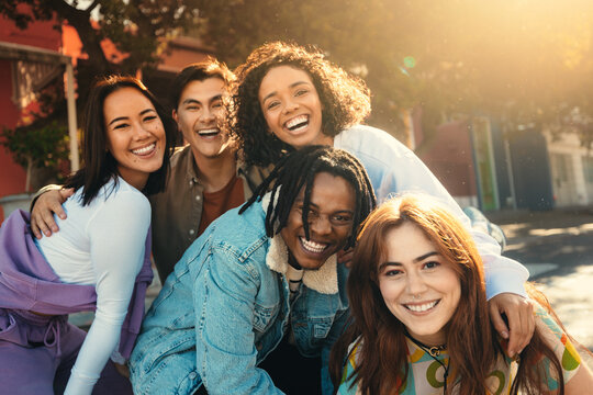 Group of friends posing outdoors with big smiles, capturing happy memories
