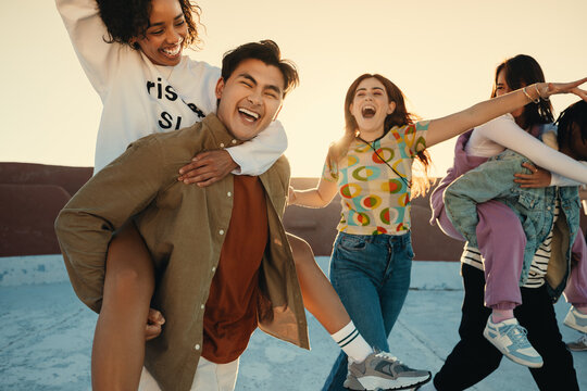 Playful friends enjoying summer day together on rooftop - Powered by Adobe