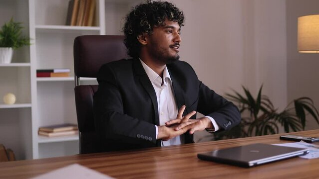 Positive tired businessman feels satisfied with distance work well done at office workplace Calm indian man relax after hard working day finished project on laptop computer indoors