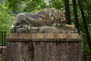 Entrance to the Covadonga cave and hermitage, framed by lush greenery and a lion statue in Asturias, Spain