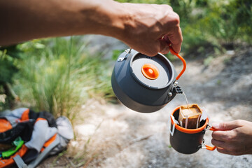 Elevate your camping experience with a hot beverage from a kettle, sipping it from a mug while...