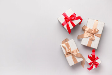 Gift boxes tied up with red and beige ribbons on grey background. Top view