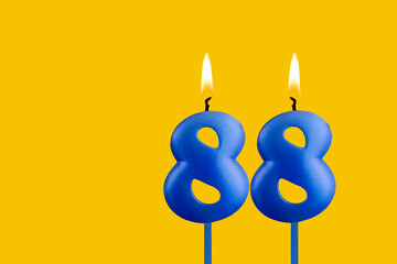 Blue birthday candle on yellow background - Number 88
