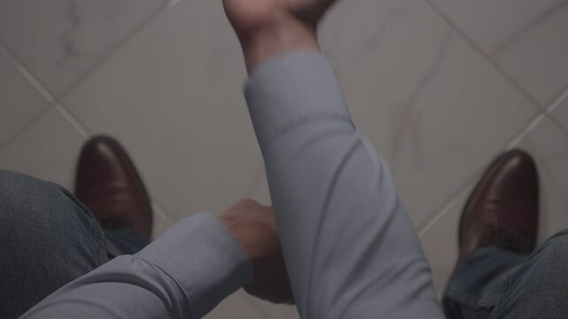 Person Flipping a Coin While Seated. A person is seated, flipping a coin with one hand while the other is poised to catch it. The image captures a moment of decision-making and chance.