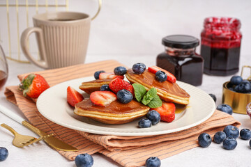 Tasty pancakes with blueberries and strawberry on white background
