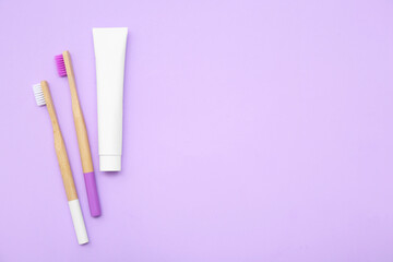 Toothbrushes with toothpaste on lilac background