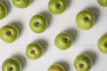 Fresh ripe green apples on white wooden table, flat lay