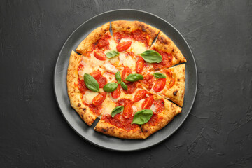 Delicious Margherita pizza on black table, top view