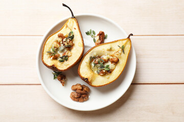 Tasty baked pears with nuts, blue cheese, thyme and honey on wooden table, top view