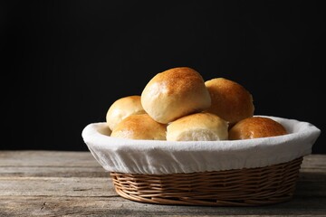 Delicious dough balls in basket on wooden table