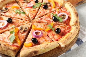 Cut delicious vegetarian pizza on light table, closeup
