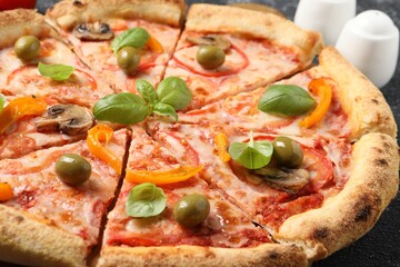 Cut delicious vegetarian pizza on table, closeup