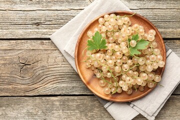 Fresh white currant berries and green leaves on wooden table, top view. Space for text