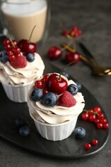 Tasty cupcakes with different berries on grey table, closeup