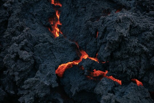 Close-up of glowing lava cracks in a volcanic rock formation
