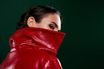 Photo of mysterious lady hide her face behind red fashionable coat isolated dark color background