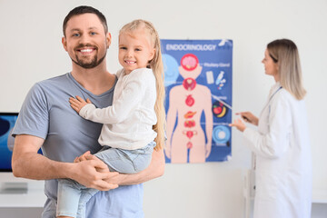 Fototapeta premium Father with his little daughter visiting endocrinologist in clinic