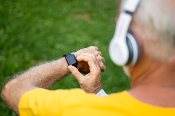 Sportsman using smart watch and measuring heart beat after running.