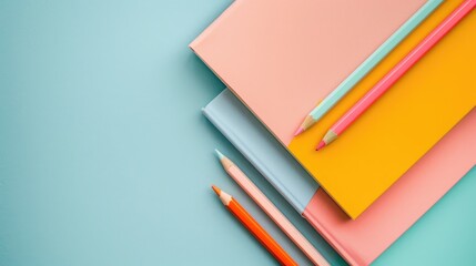 Top view of colorful pastel notebooks and pencils on a light grey background for the back to school theme
