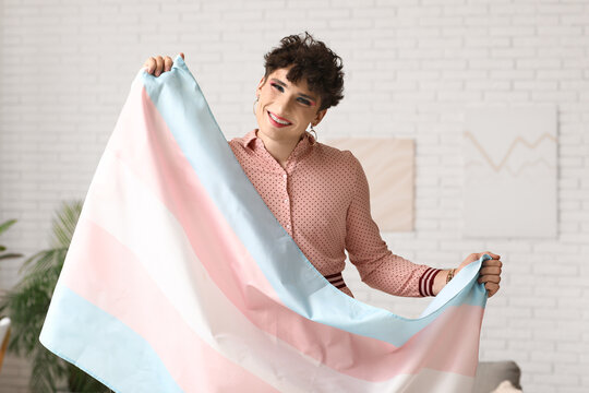 Young transgender woman with flag at home