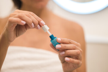 Woman applying anti-age serum on her skin