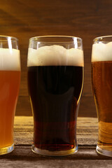 Glasses with different types of beer on wooden table