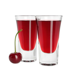 Shot glasses of delicious cherry liqueur and juicy berry isolated on white