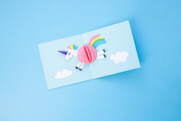 Vibrant three-dimensional paper craft project a white unicorn, crafting process, showcasing creativity and skill