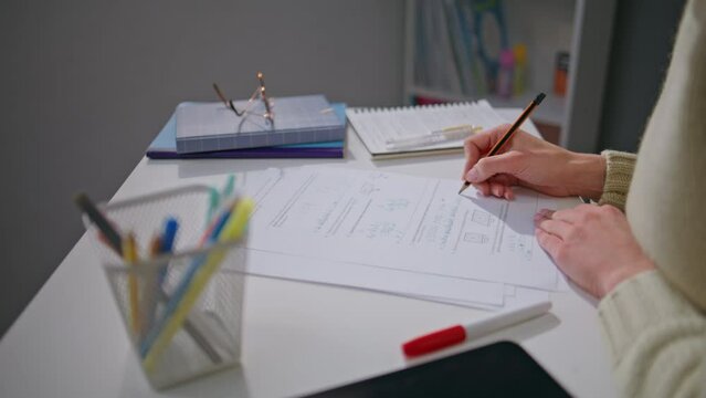 Teacher hands checking homework at school workplace closeup. Woman working alone