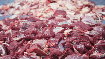 A pile of raw beef that has been cut into pieces. Focus selected