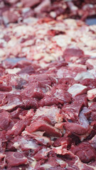 A pile of raw beef that has been cut into pieces. Focus selected