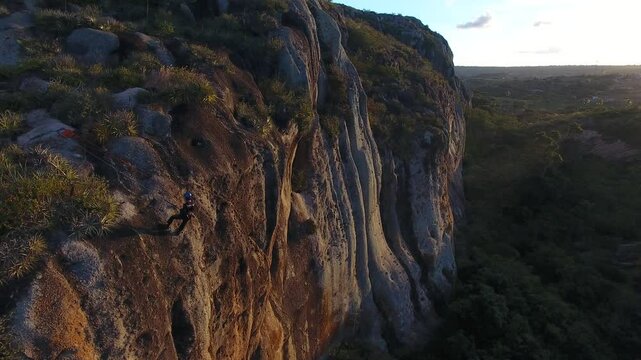 Aerial view of man rappeling the Cruzeiro Hill - Serra de S&atilde;o Bento, Rio Grande do Norte, Brazil
