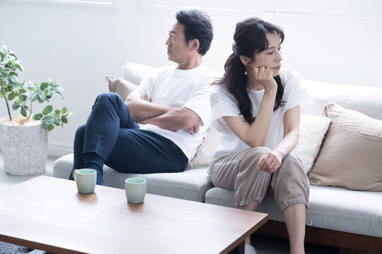 ソファーに座る倦怠期やケンカをする50代夫婦　仲が悪い冷え切った夫婦のイメージ　全身