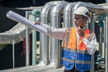 Male engineer inspects air and water pipelines in the engineering system area of ​​the factory outside where various pipelines are designed modernly. Technicians work in the petrochemical industry.