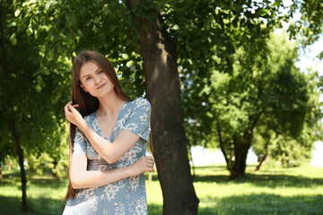 Fototapeta premium Portrait of beautiful woman in summer park. Space for text