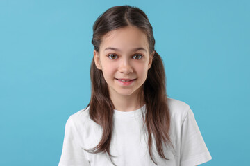 Portrait of beautiful girl on light blue background