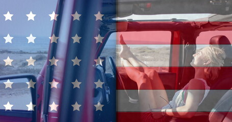 Image of flag of usa over caucasian woman in car on beach