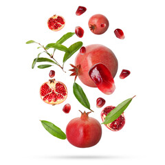 Fresh pomegranates, seeds and leaves in air on white background