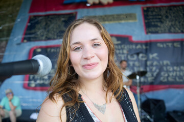 Female performer on stage. Portrait of woman at a microphone.