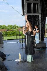 Female performer on stage. Portrait of woman singing at a microphone.