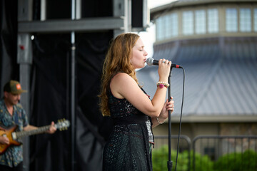 Female performer on stage. Portrait of woman singing at a microphone.