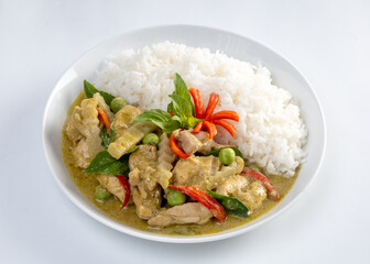 Chicken green curry with coconut shoots over rice  isolated on white background.