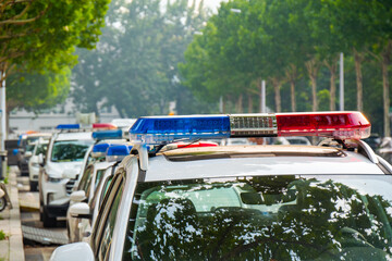 Police lights on car during traffic surveillance on the city road. Flash light on the vehicle of the Emergency Services. Red and blue flashes on the cars of the Patrol specialized unity.  © JUN LI