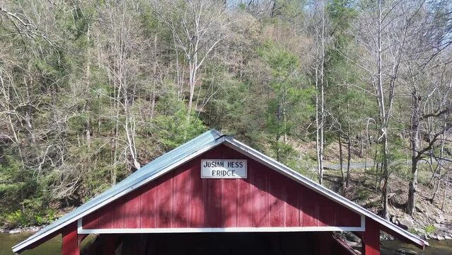 Josiah Hess covered bridge near Orangeville PA. Closeup shot of a bridge portal that rises to reveal the roof and forest beyond. Shot on an early Spring day.
